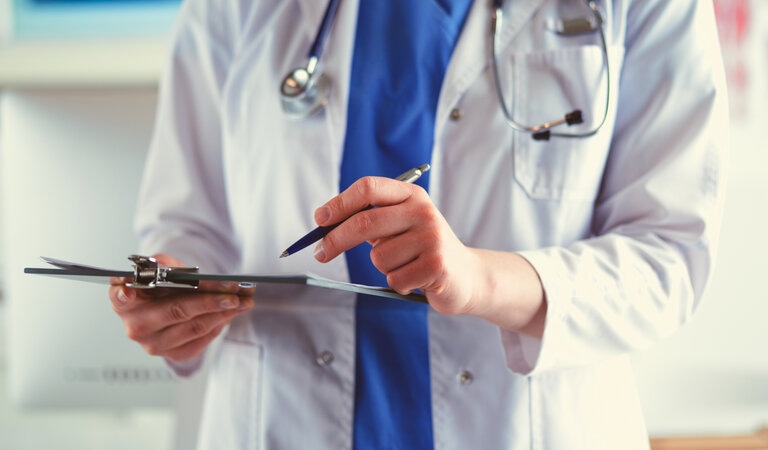 Medical doctor with clipboard and pen Adobe stock licenced (1)