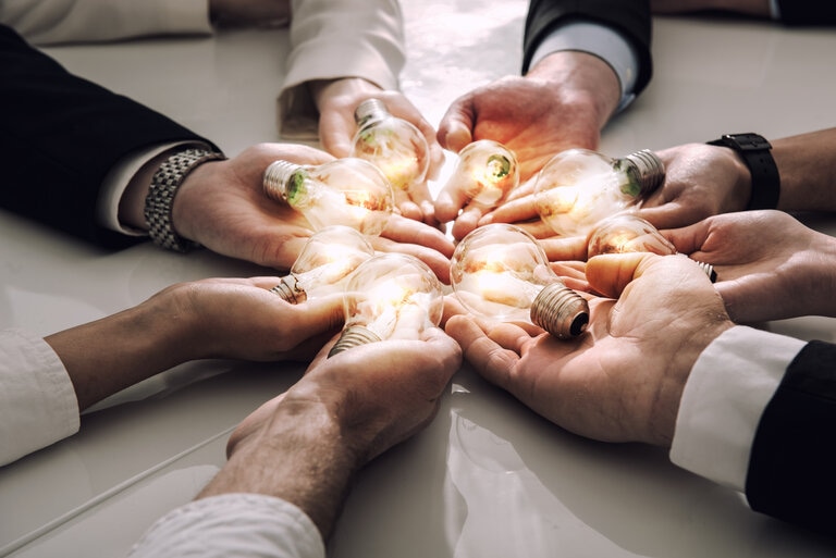 Innovation and partnership hands together with lightbulbs Adobe stock licenced 2022 (1)